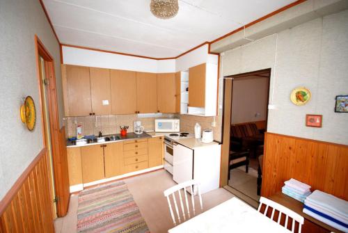 a kitchen with brown cabinets and a white refrigerator at Jämsän Gasthaus in Jämsä