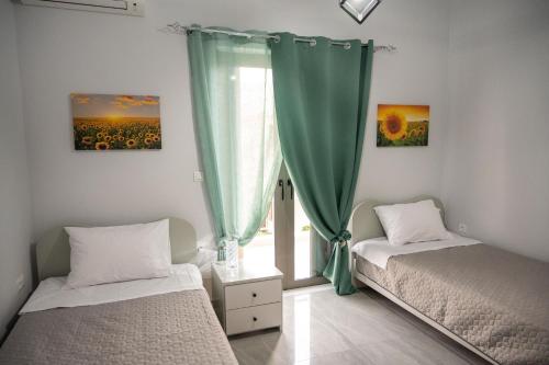 トロにある3S Tolo Apartmentsの窓のある部屋にツインベッドが2台