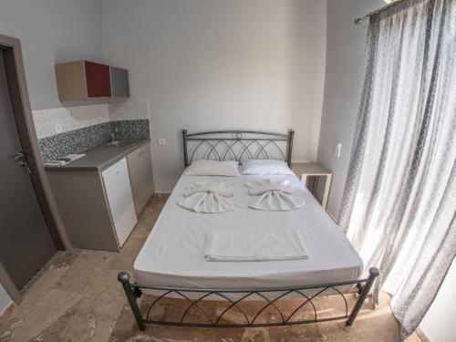 a small bedroom with a bed and a kitchen at Pavlopetri in Vingláfia