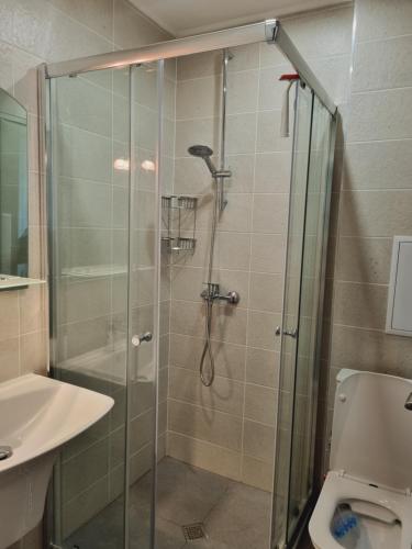 a bathroom with a shower and a toilet and a sink at ATEA apartments in Kavarna