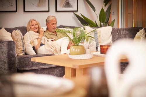 a man and a woman sitting on a couch at Loch Lomond Holiday Park in Inversnaid