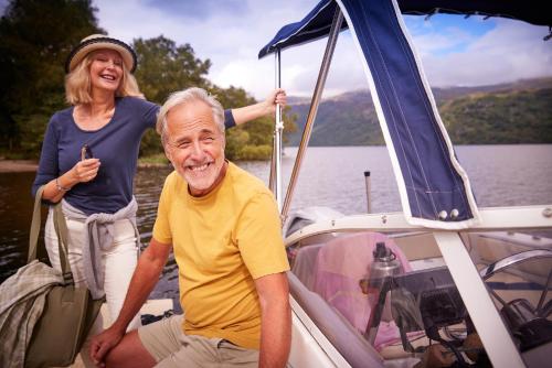 a woman and an older man sitting on a boat at Loch Lomond Holiday Park in Inversnaid