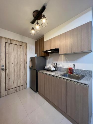 a kitchen with a sink and a refrigerator at INSPIRIA TOWER CONDOMINIUM 1911 in Davao City