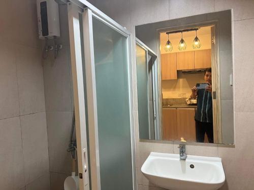 a person taking a picture of a sink in a bathroom at INSPIRIA TOWER CONDOMINIUM 1911 in Davao City
