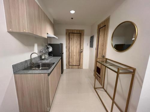 a small kitchen with a sink and a mirror at INSPIRIA TOWER CONDOMINIUM 1911 in Davao City