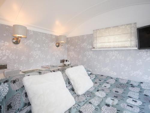 a bedroom with a bed with two white pillows at Shepherds Stone in Holyhead