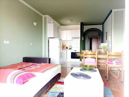 a room with a bed and a kitchen with a table at Meeresblick Apartment S4 in Promajna