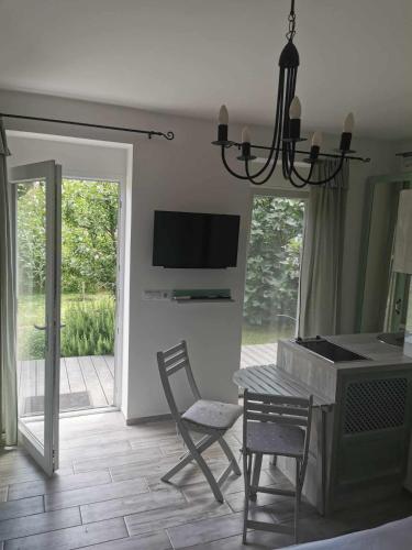a living room with a table and chairs and a television at Zsálya Vendégház in Csopak
