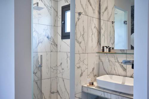 a bathroom with a white sink and a mirror at Mirabilia Boutique Hotel in Kriopigi