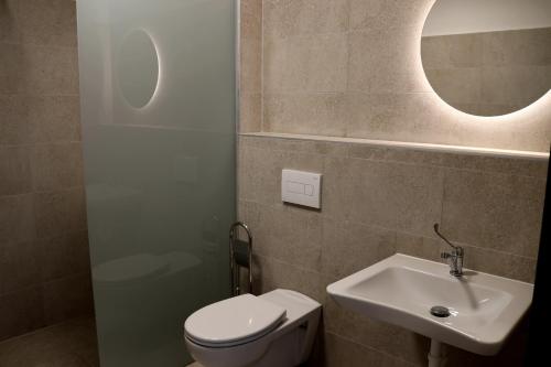 a bathroom with a toilet and a sink and a mirror at Zafír in Dunajská Streda