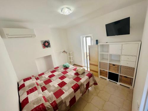 a bedroom with a bed and a flat screen tv at Mini villino Ladispoli Centro Mare in Ladispoli