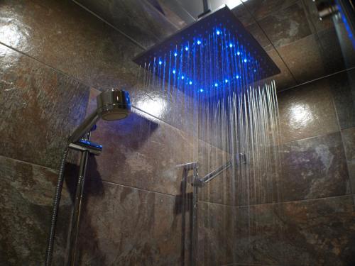 a shower with a blue light in a bathroom at Suite Rural Carenas in Carenas