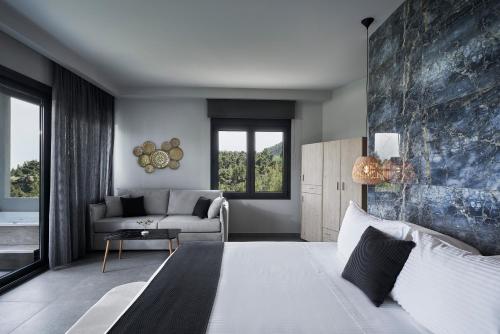 sypialnia z dużym łóżkiem i kanapą w obiekcie Mirabilia Boutique Hotel w mieście Kriopigi