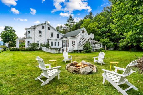 a group of chairs around a fire pit in front of a house at 10 Min to Mountains Long Trail Suite in Bridgewater