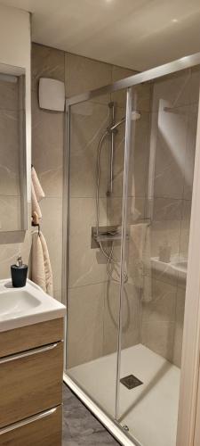 La salle de bains est pourvue d'une douche avec une porte en verre. dans l'établissement La cachette sarladaise, à Sarlat-la-Canéda