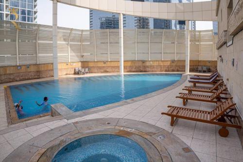 una gran piscina con 2 personas. en Your Luxurious 2BR Al Reem Escape at Mangrove Place en Abu Dabi