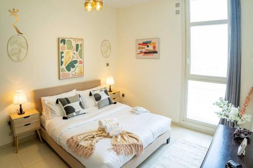 Un dormitorio con una cama blanca con una manta. en Your Luxurious 2BR Al Reem Escape at Mangrove Place en Abu Dabi