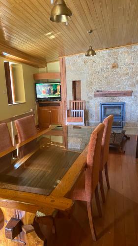 a dining room with a wooden table and a fireplace at Casa do Planalto Mirandês in Miranda do Douro