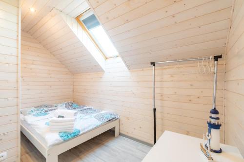 una sauna con una cama en una sala de madera en Domki Piaskowa11 Palm Resort & Wellness, en Łeba