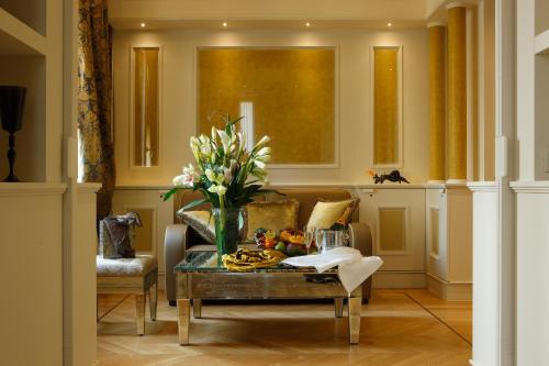 a living room with a table with flowers on it at Canaletto Luxury Suites - San Marco Luxury in Venice