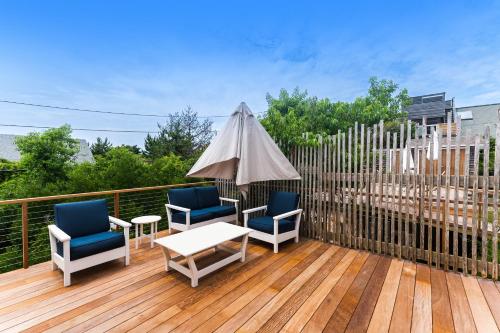 a deck with two chairs and a table and an umbrella at Huron Hideaway in Ocean Bay Park