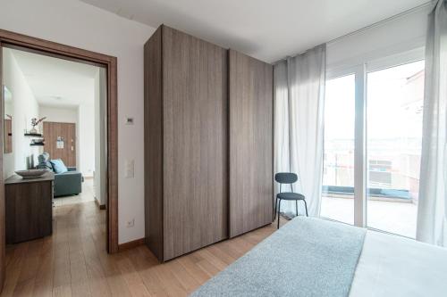 a bedroom with a bed and a chair in it at Roggia Apartments by Quokka 360 - central flats with parking space in Lugano