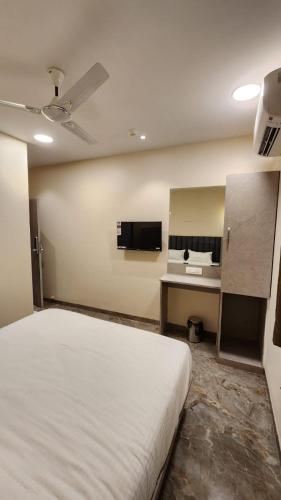 a bedroom with a bed and a sink and a desk at Peace International in Mumbai