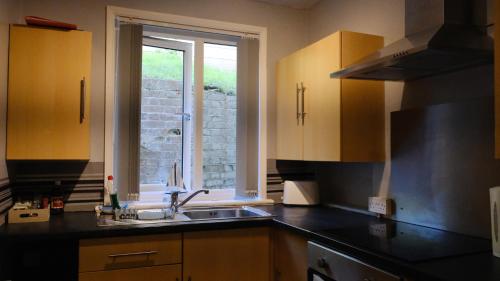 a kitchen with a sink and a window at Commanders Cabin EV point in Looe