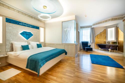 a hotel room with a bed and a bath tub at Schlosshotel Lacknerhof in Flachau