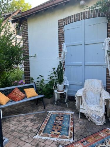 a patio with a couch and a chair next to a building at yinloft in Sainte-Gemme-Moronval