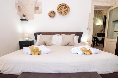 een slaapkamer met een wit bed met 2 kussens erop bij Terrazza Mazzini - Suite Porta Piccènne in Cisternino
