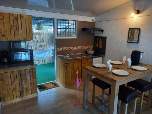 a kitchen with a wooden table with chairs and a sink at ResaLoc - Maison Traditionnelle avec jardin in Saint-André