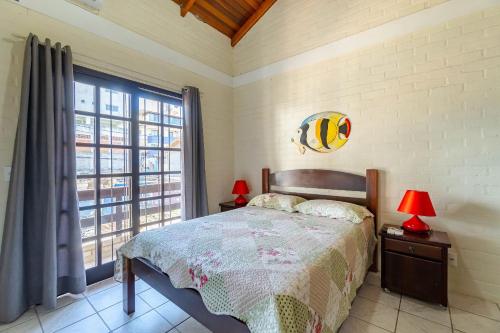 1 dormitorio con cama y ventana grande en Sobrado de Praia - 1 Quadra e Meia da Praia, para até 5 pessoas, en Bombinhas