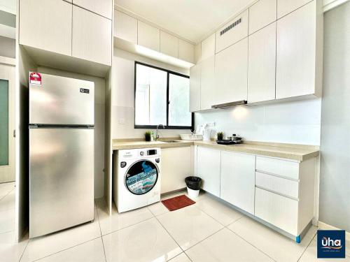 a kitchen with a refrigerator and a washing machine at Macrolink Medini by RR JBcity in Nusajaya