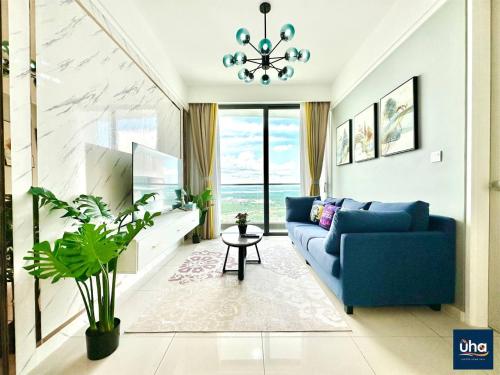 a living room with a blue couch and a table at Macrolink Medini by RR JBcity in Nusajaya