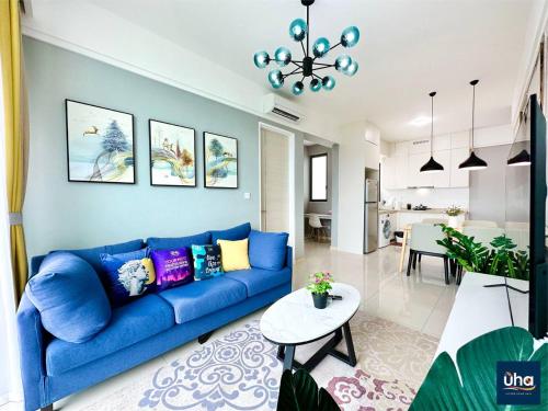 a living room with a blue couch and a table at Macrolink Medini by RR JBcity in Nusajaya