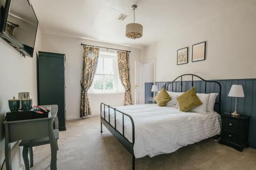 1 dormitorio con cama, escritorio y ventana en Miresfield Farm Bed & Breakfast en Malham