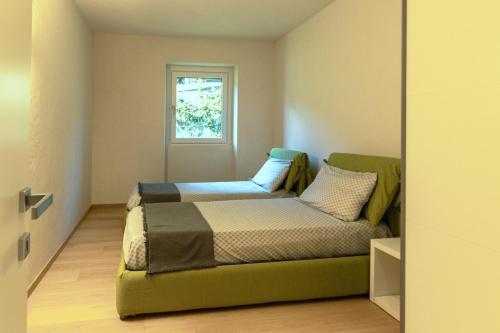 a small bedroom with a bed and a window at Style apartments VdA in Senin