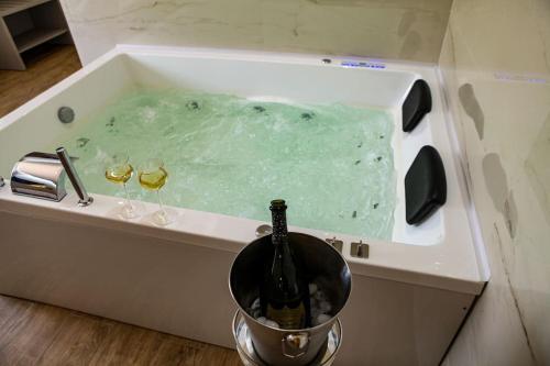 a bottle of champagne in a tub with two wine glasses at Luxury - 5 Stars - Suite with a jacuzzi 70's rooms in Trapani