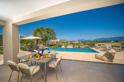a patio with a table and chairs and a swimming pool at Claire villa in Sami