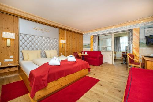 two stuffed animals sitting on a bed in a room at Schlosshotel Lacknerhof in Flachau