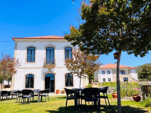 Quinta de Fiães في Vilar de Maçada: مجموعة طاولات وكراسي أمام المبنى