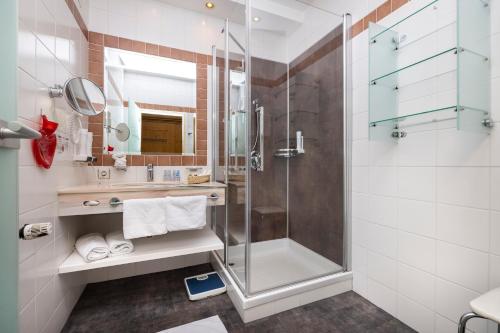 y baño con ducha y lavamanos. en Schlosshotel Lacknerhof, en Flachau
