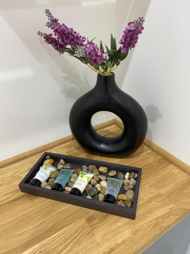 a black vase with flowers in it sitting on a table at 51 Innes Street Apartment in Inverness