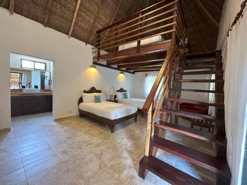 ein Schlafzimmer mit einer Treppe und einem Bett in einem Zimmer in der Unterkunft Na Balam Hotel in Isla Mujeres