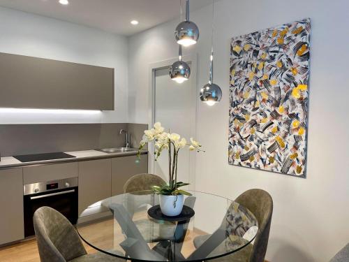 a kitchen and dining room with a glass table and chairs at Clavis Luxury Apartments in Chiavenna