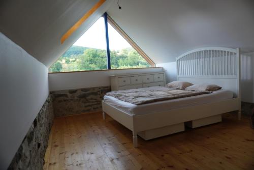 a bedroom with a bed and a large window at Stodola Počúvadlo in Počúvadlo