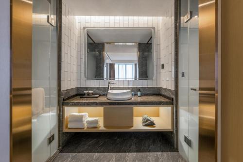 a bathroom with a sink and a mirror at Manju Hotel in Nantong