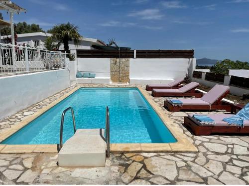 a swimming pool with two lounge chairs at Hestia's House in Meganisi