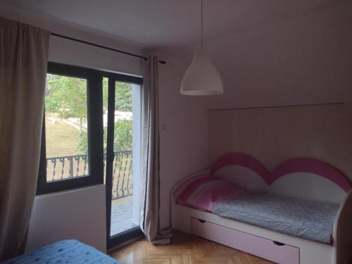 a bedroom with a bed and a large window at Kosmajska Vila in Koraćica
